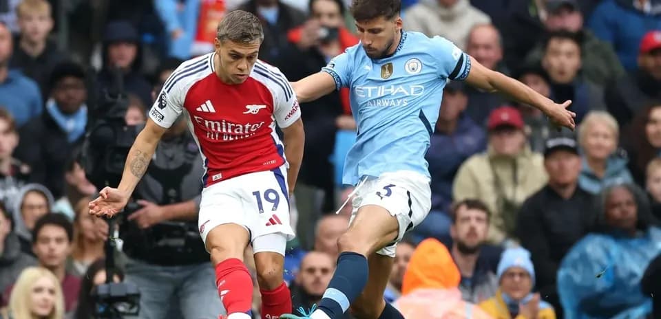 Un joueur d'Arsenal dribble un joueur de Manchester City