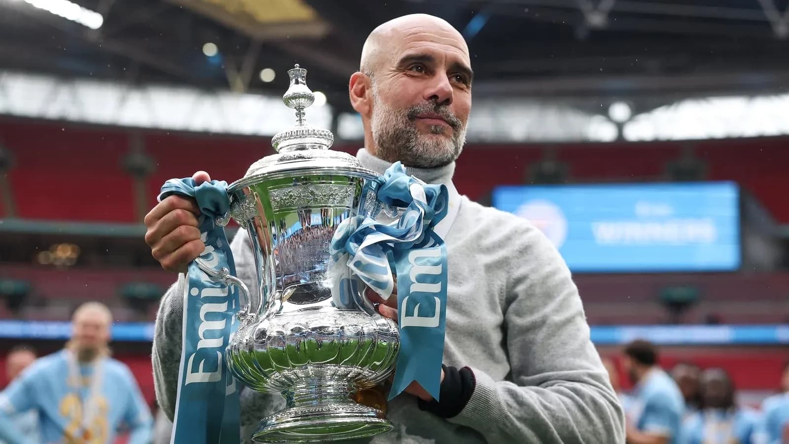 Entraîneur tenant le trophée à Wembley