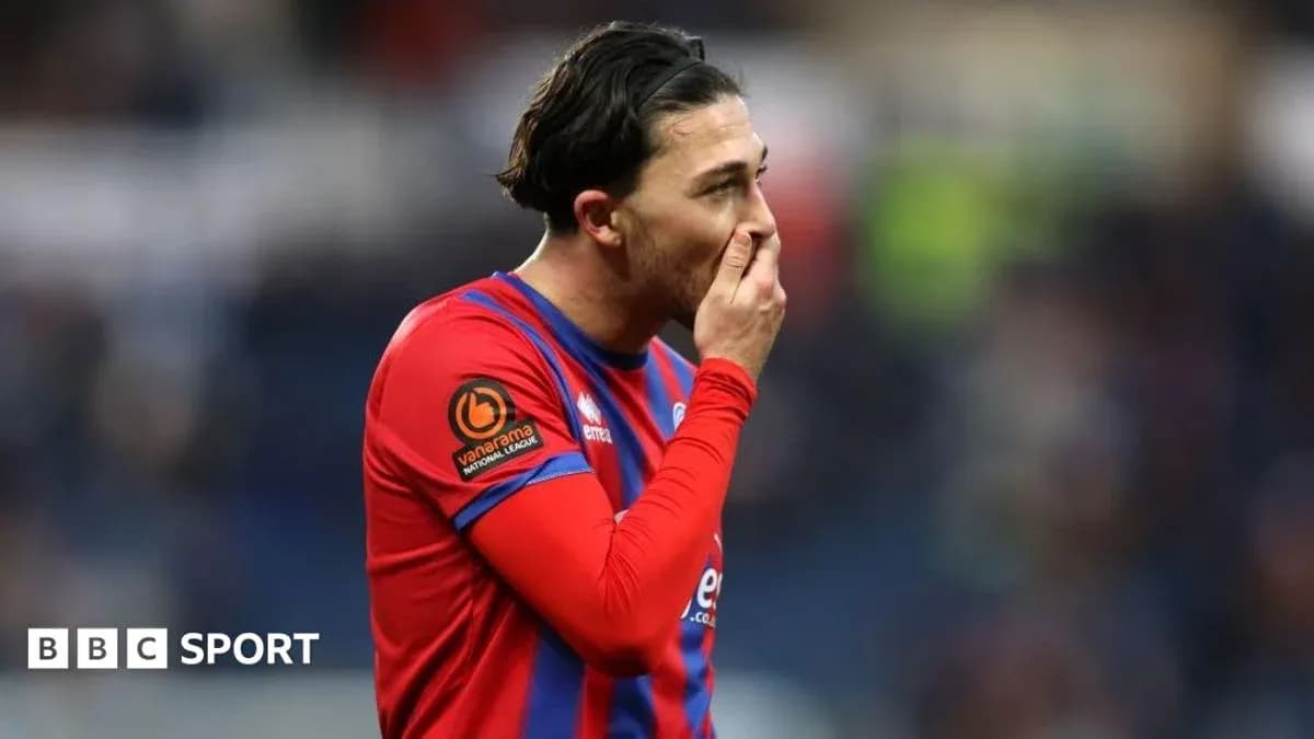 Joueur en maillot rouge et bleu touchant son visage