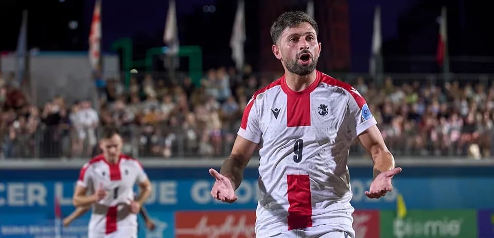 Joueur en maillot blanc réagissant sur le terrain