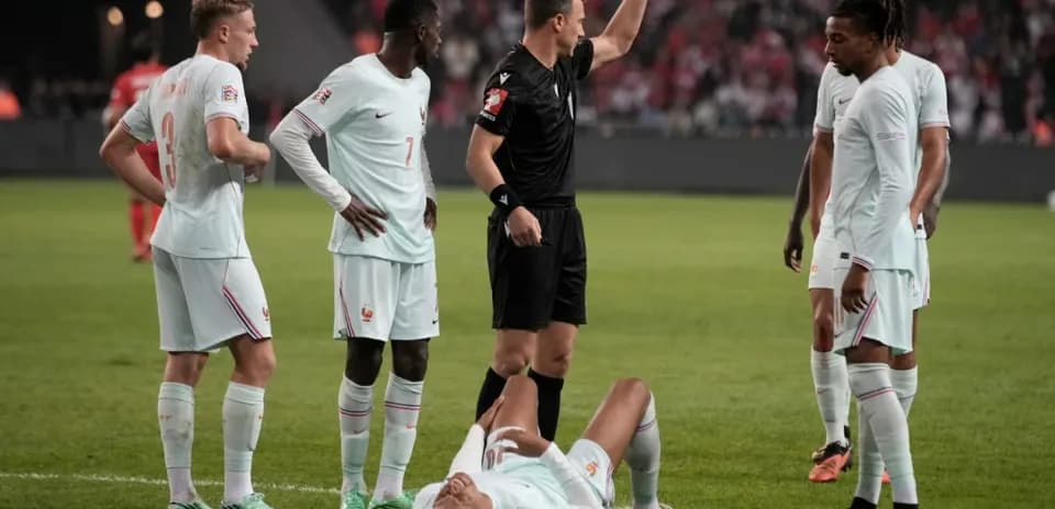 Joueurs français autour d'un arbitre, joueur au sol