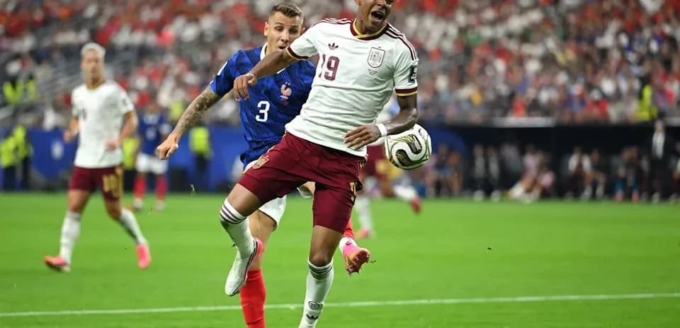 Joueur espagnol dribblant face à un défenseur français