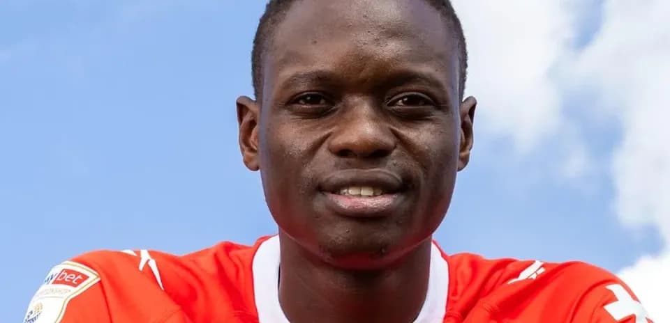 Joueur souriant en maillot rouge sur fond bleu
