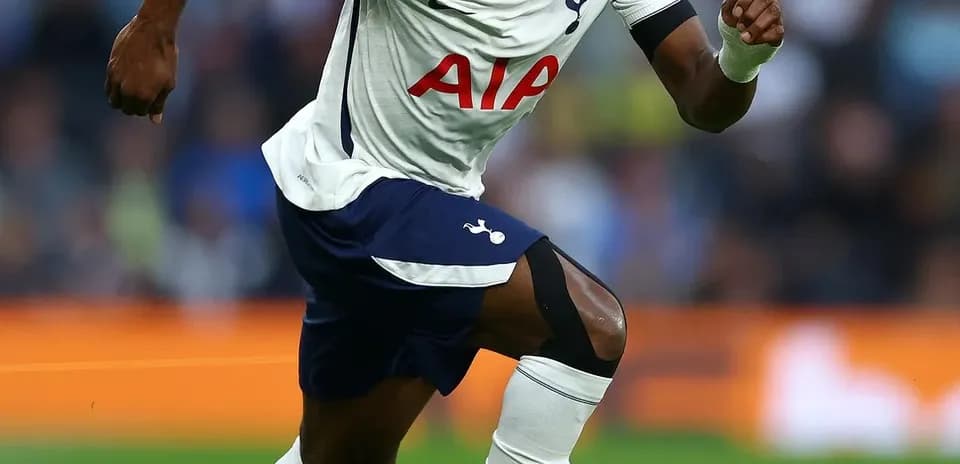 Joueur de Tottenham courant avec le ballon sur le terrain