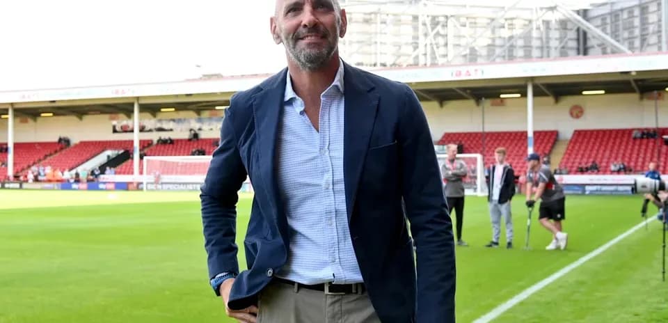 Homme en costume marchant sur le terrain de football