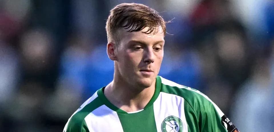 Joueur portant un maillot vert et blanc sur le terrain