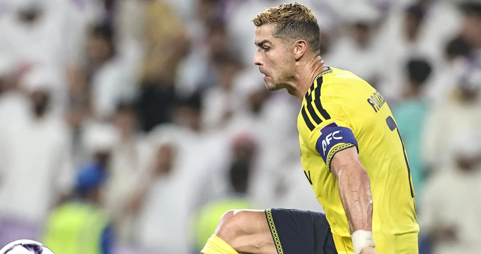 Joueur en maillot jaune dribblant lors d'un match