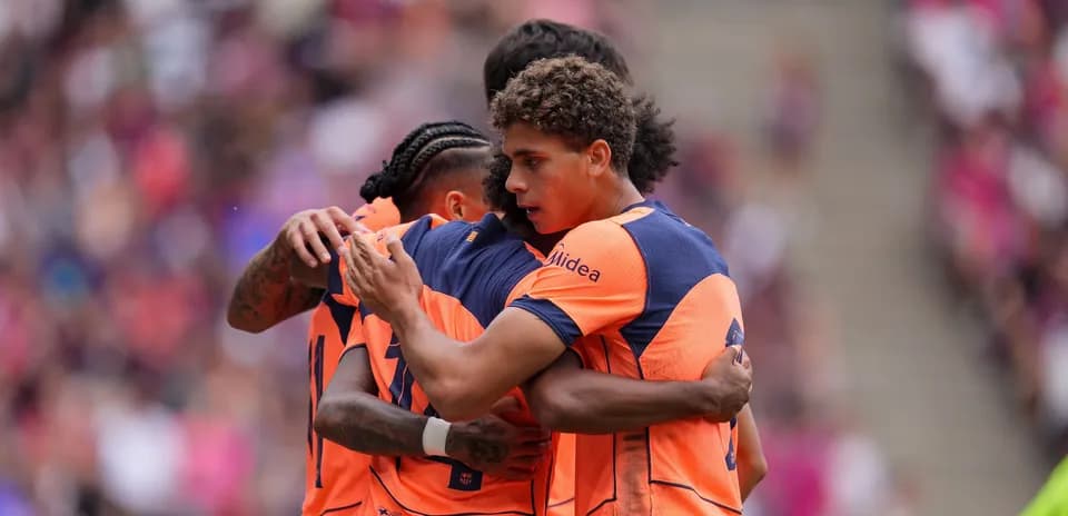 Joueurs célébrant un but en équipe sur le terrain