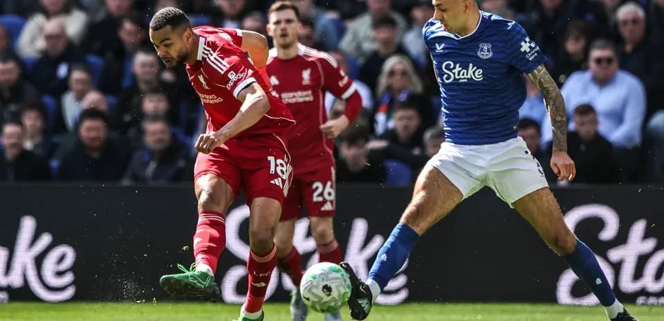 Joueur de Liverpool dribblant un adversaire d'Everton