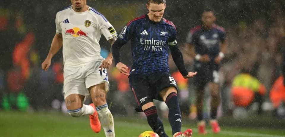 Joueur d'Arsenal dribblant sous la pluie