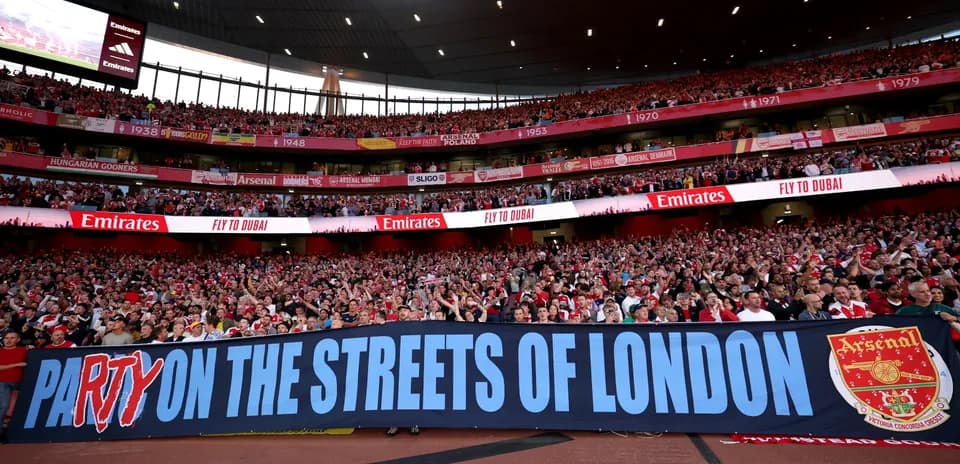 Supporters holding banner at Arsenal match
