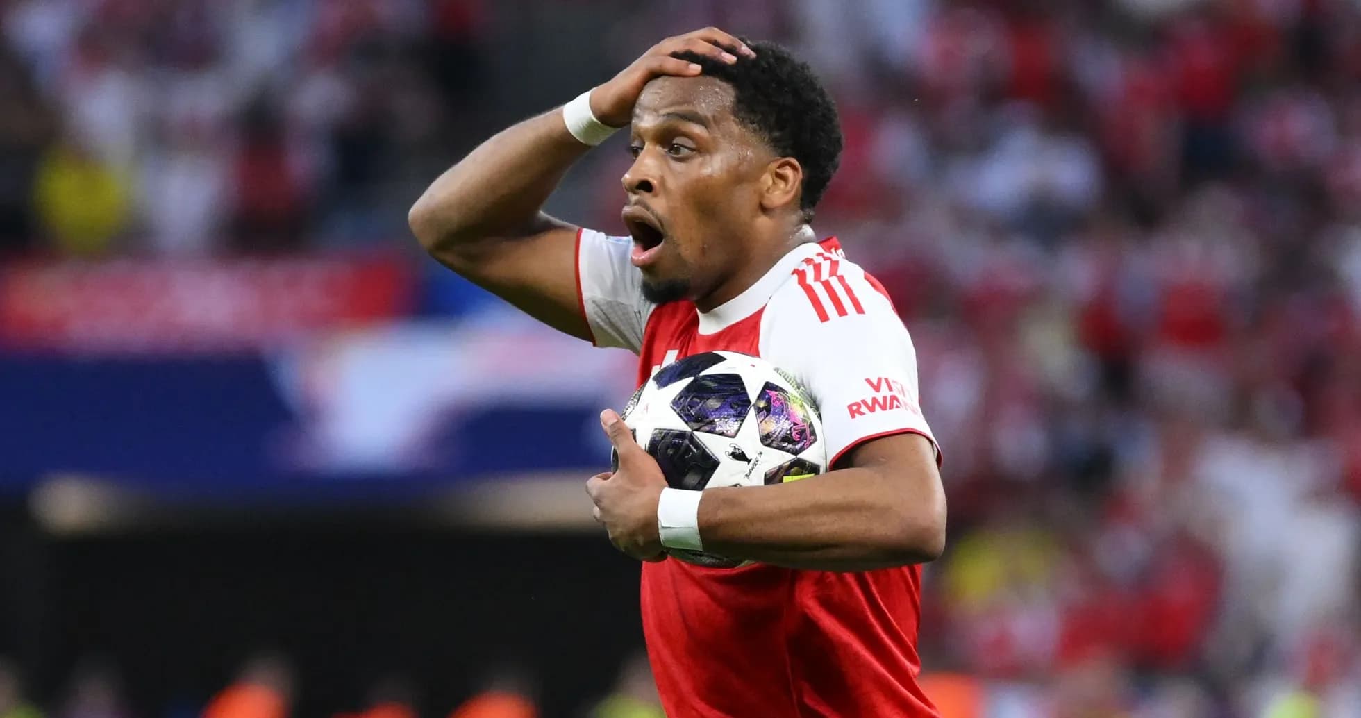 Joueur d'Ajax tenant un ballon avec surprise
