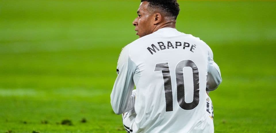 Joueur assis sur le terrain, maillot Mbappé 10