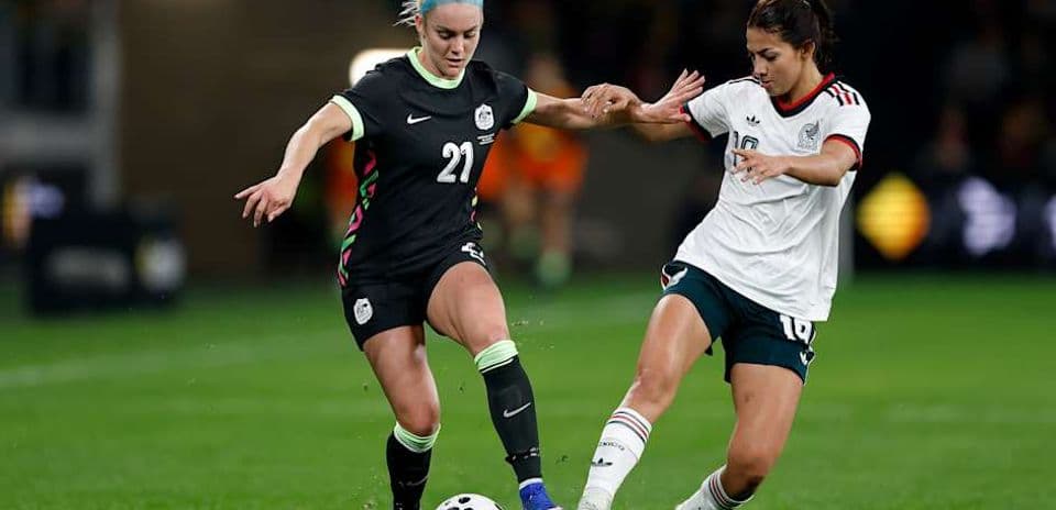 Joueuse américaine dribblant face à une joueuse mexicaine