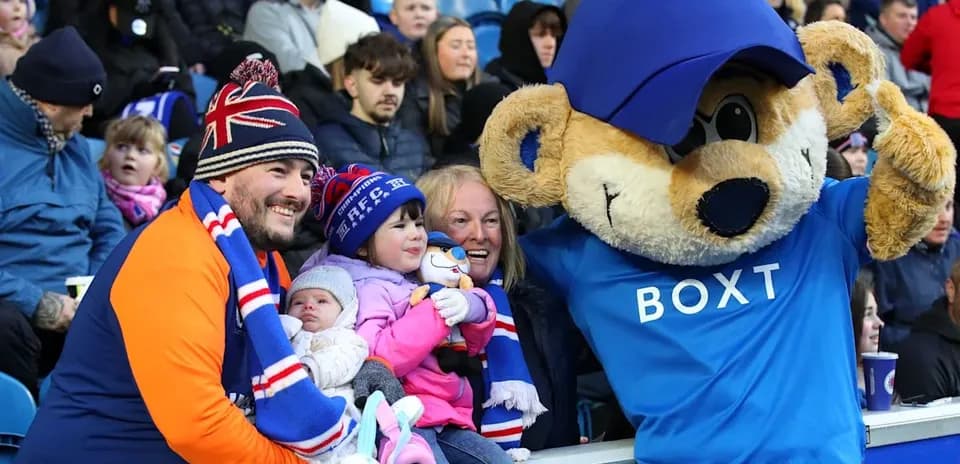 Famille avec mascotte au match de football
