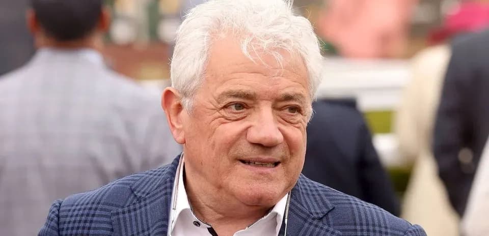 Homme avec des cheveux blancs souriant à un événement