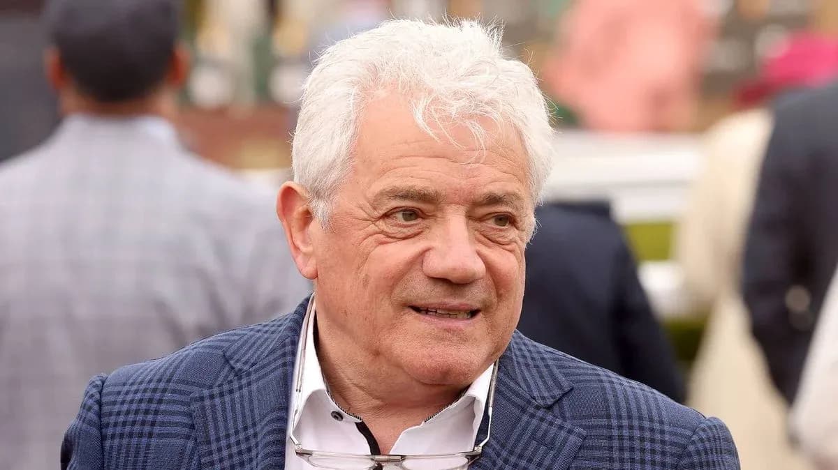 Homme avec des cheveux blancs souriant à un événement