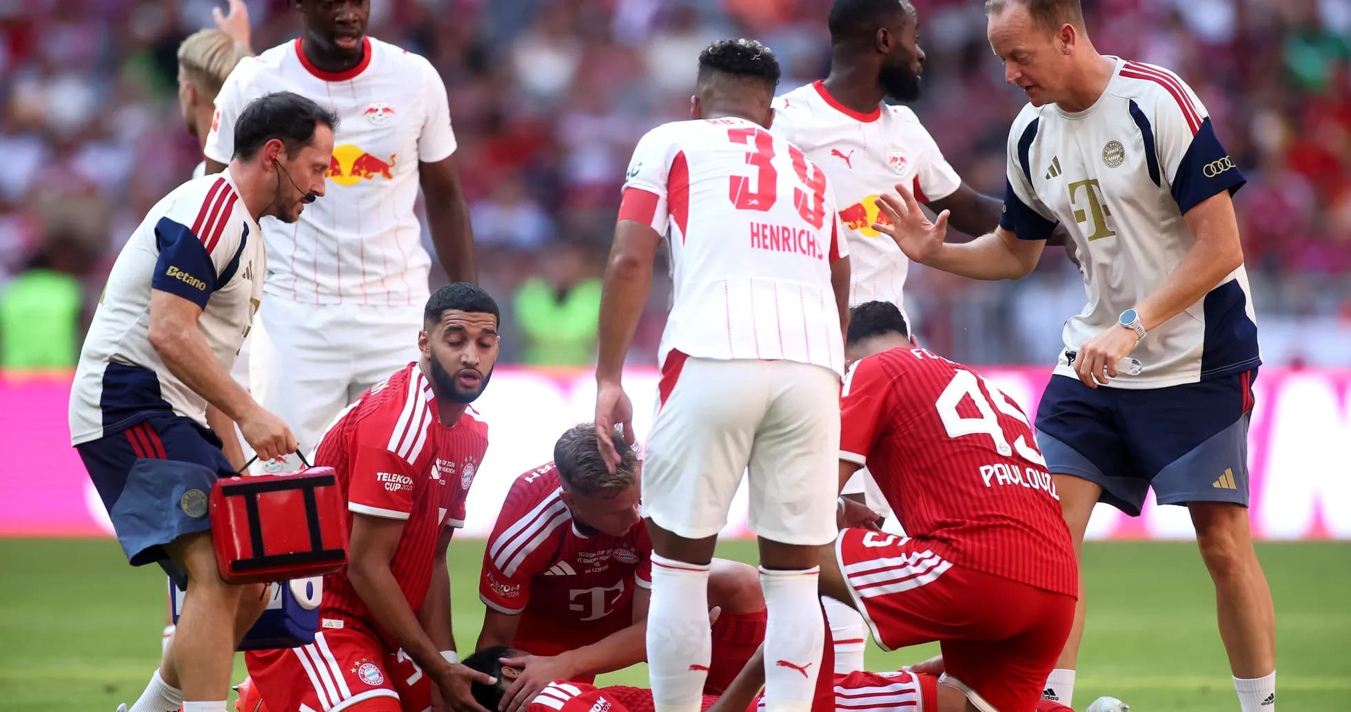Joueurs et staff soignant un joueur blessé sur le terrain