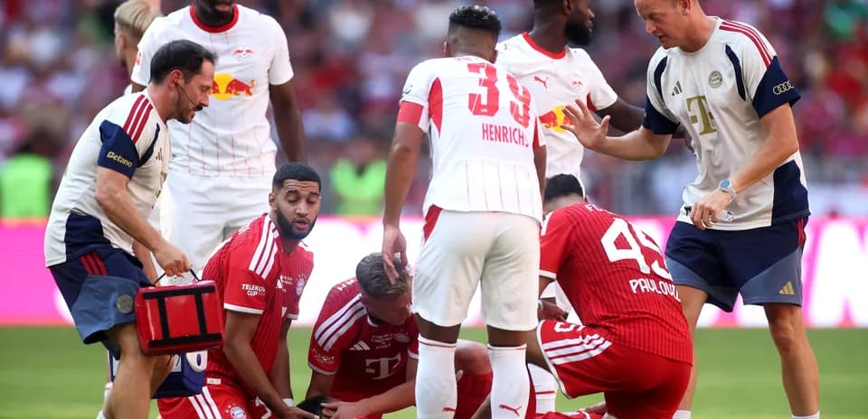 Joueurs et staff soignant un joueur blessé sur le terrain