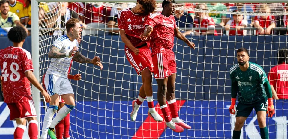 Deux joueurs de Liverpool sautant pour un ballon aérien