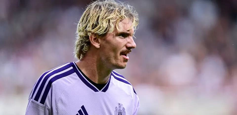 Joueur de Newcastle en maillot violet sur le terrain