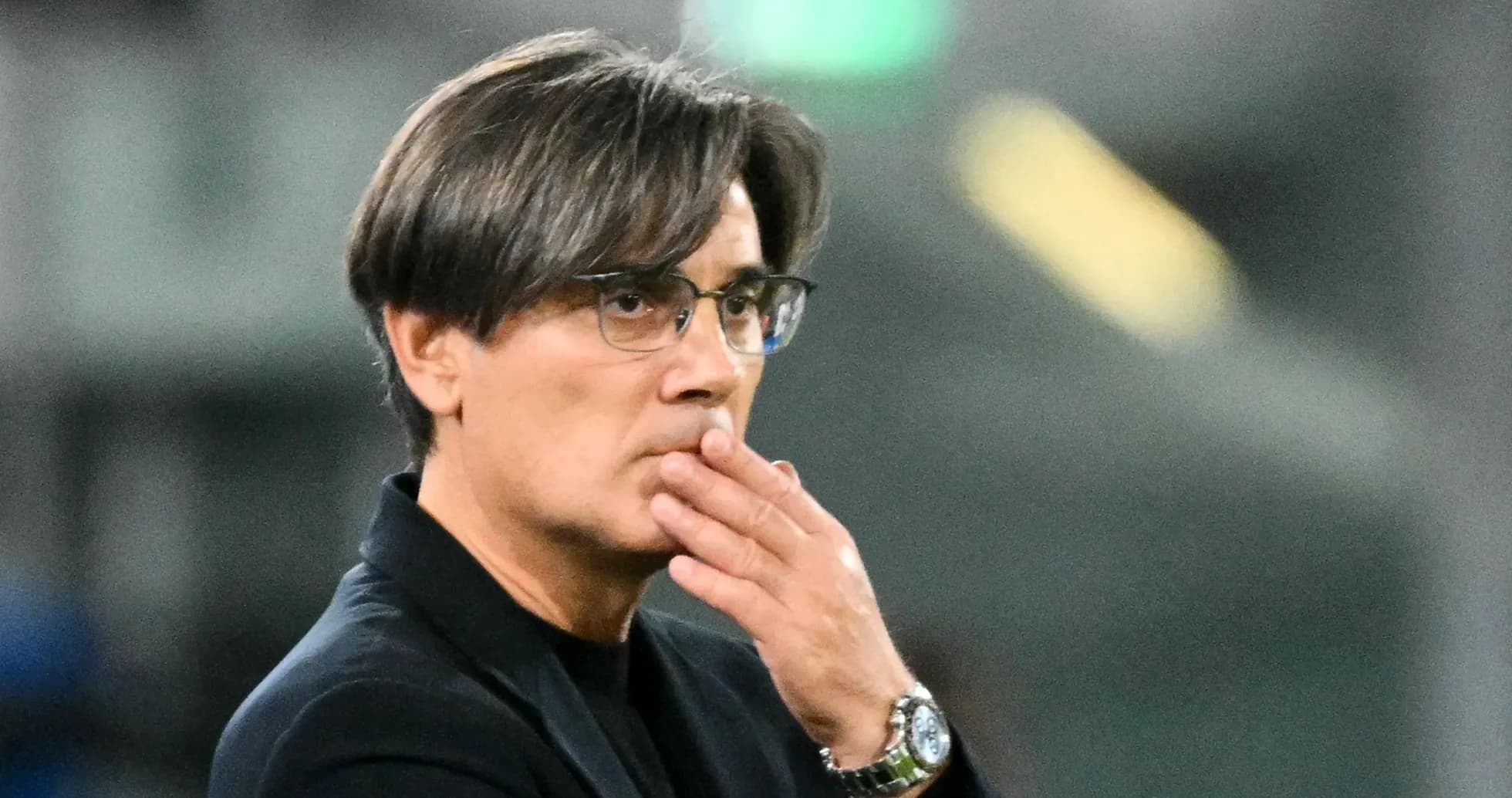 Entraîneur observant le match avec une main sur la bouche