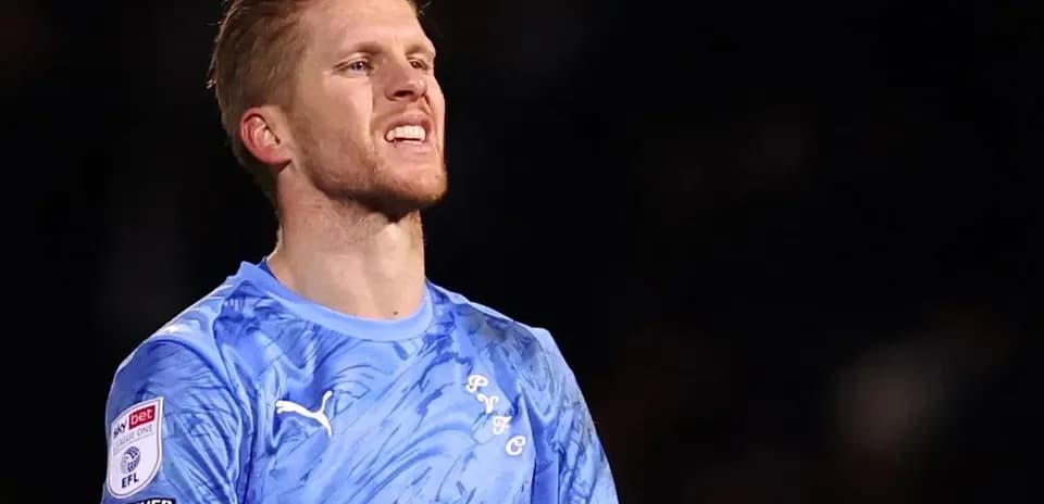 Gardien de but en tenue bleue sur le terrain