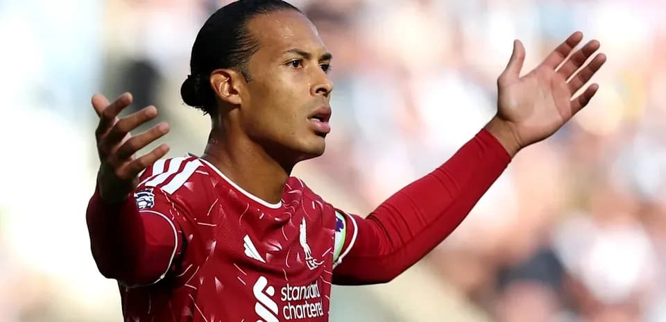 Joueur de Liverpool levant les bras sur le terrain