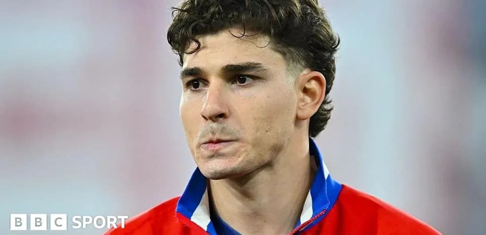 Joueur en maillot rouge, regard pensif avant le match