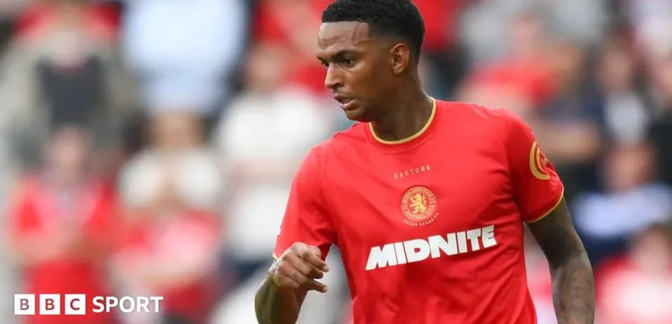 Joueur en maillot rouge courant sur le terrain