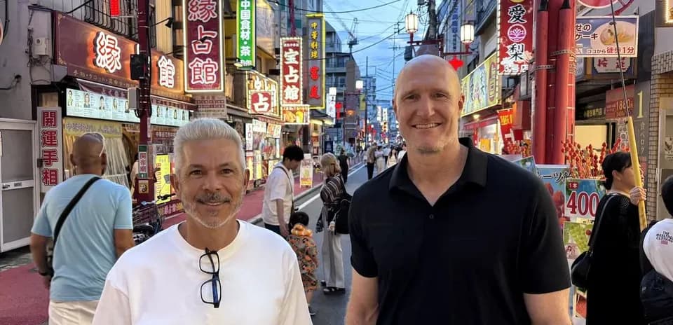 Deux hommes souriant dans une rue animée de la ville
