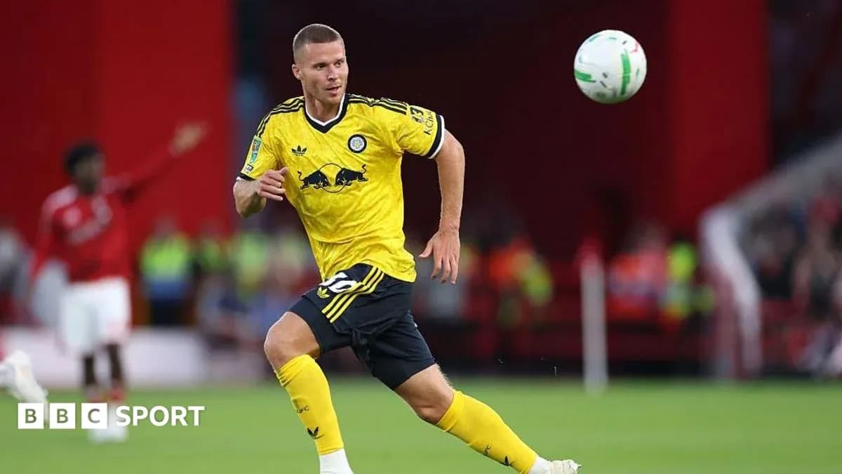 Joueur en maillot jaune courant avec le ballon