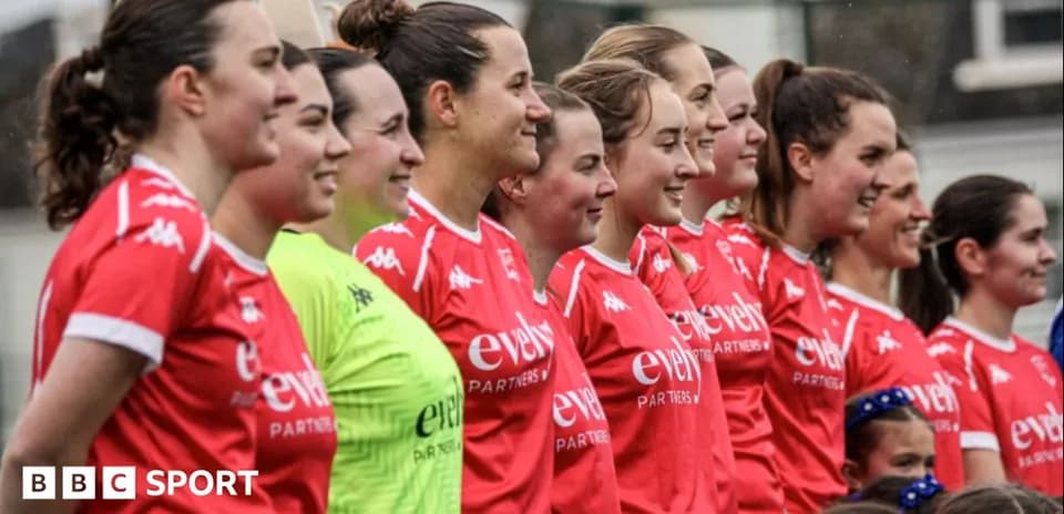 Équipe féminine en maillots rouges posant ensemble