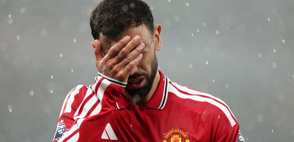 Joueur de Manchester United se couvrant le visage sous la pluie