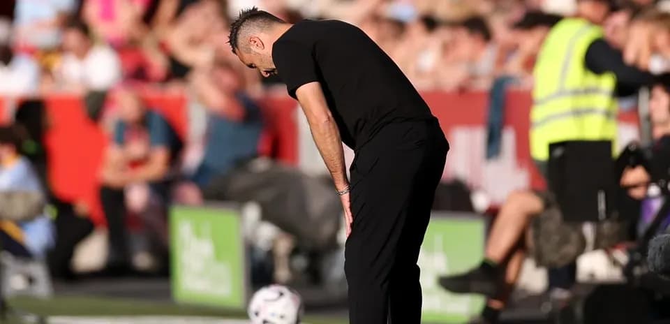 Entraîneur penché près du ballon sur le bord du terrain
