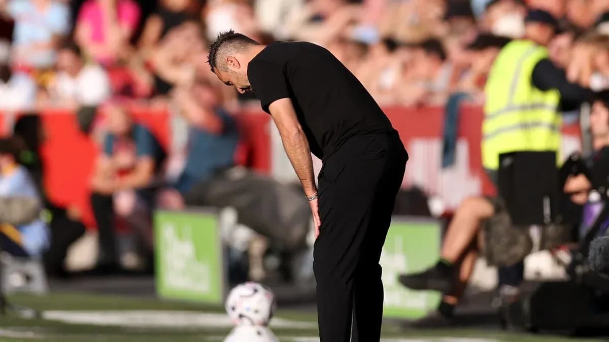 Entraîneur penché près du ballon sur le bord du terrain