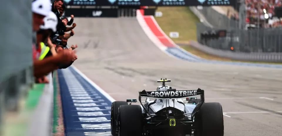 Voiture de course passant devant des spectateurs en tribune