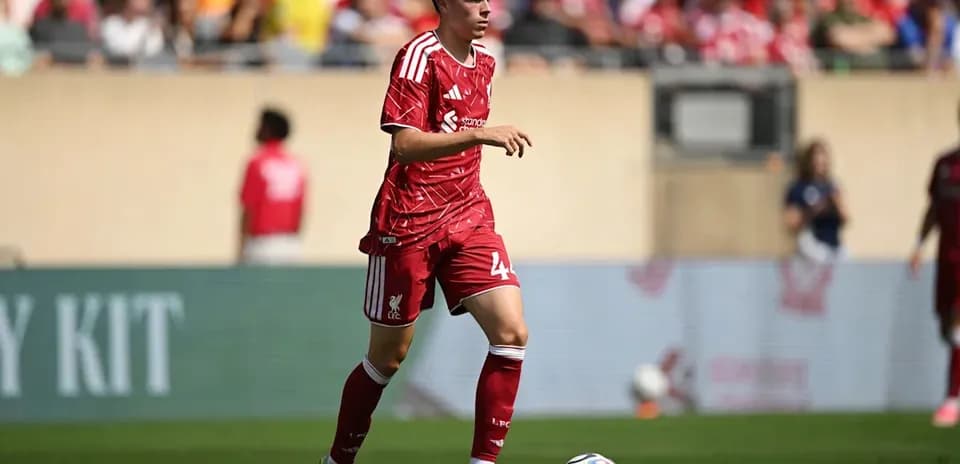 Joueur de Liverpool courant avec le ballon sur le terrain