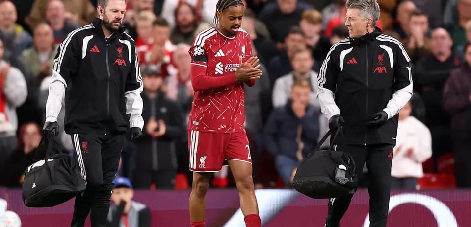 Joueur de Liverpool sortant avec des médecins en soutien