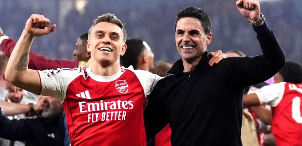 Joueur d'Arsenal célébrant avec l'entraîneur après un match