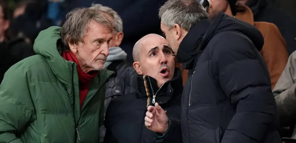 Trois hommes discutant dans les tribunes du stade