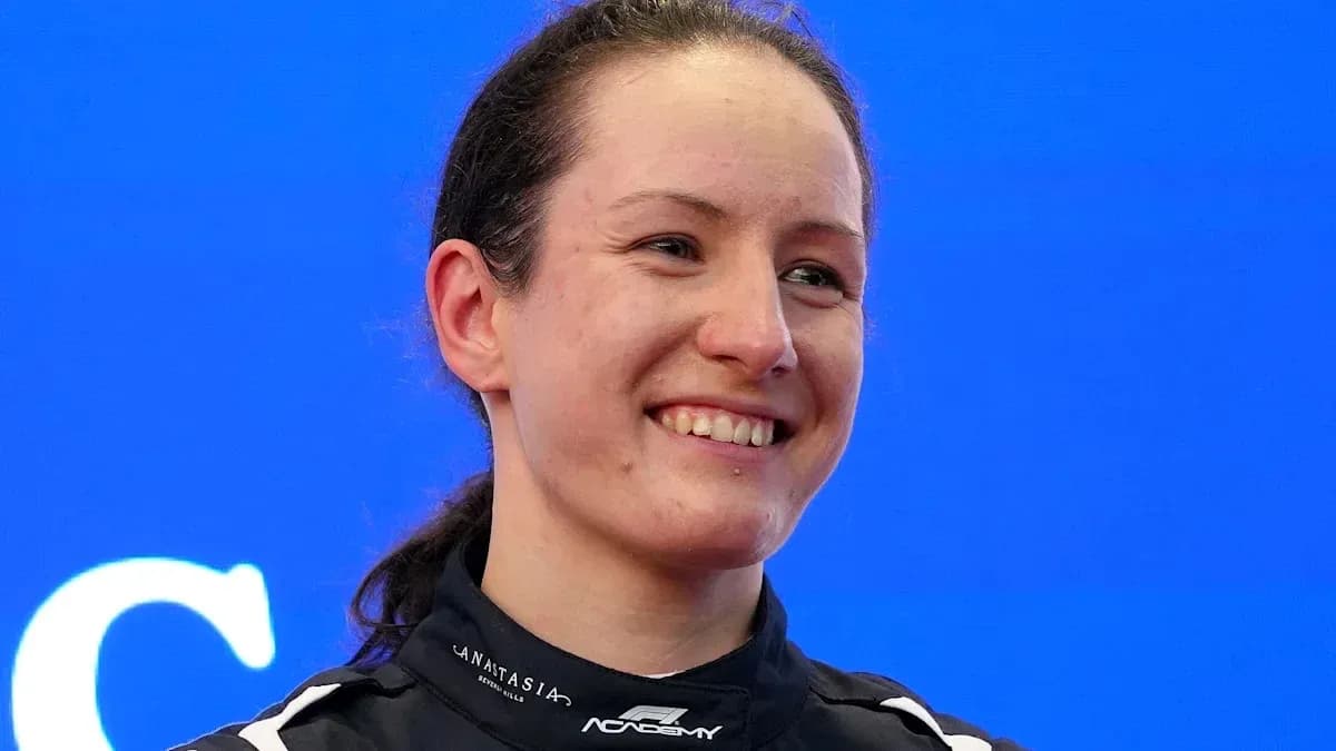 Pilote souriante en combinaison de course sur fond bleu