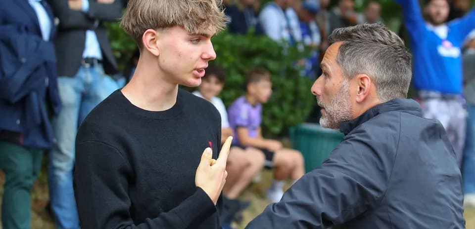 Discussion between two individuals near a crowd