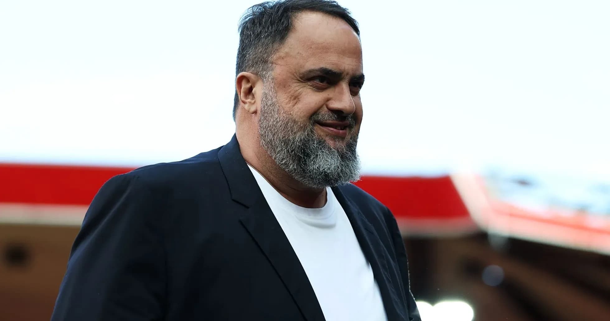 Homme souriant portant un blazer noir et un t-shirt blanc