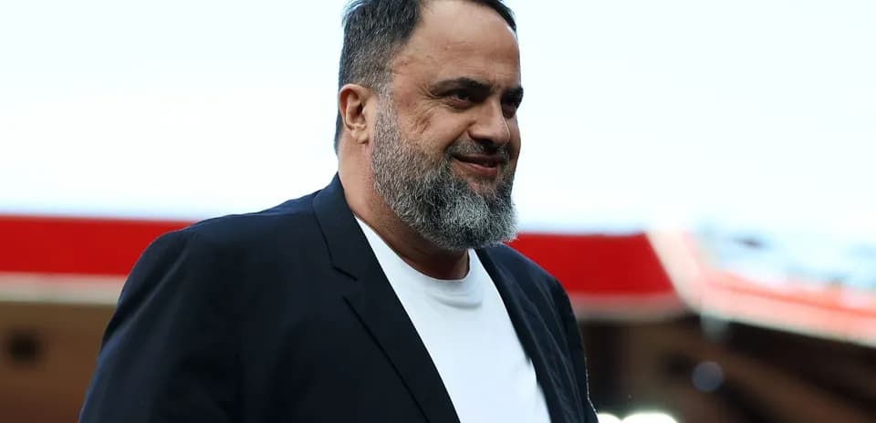 Homme souriant portant un blazer noir et un t-shirt blanc