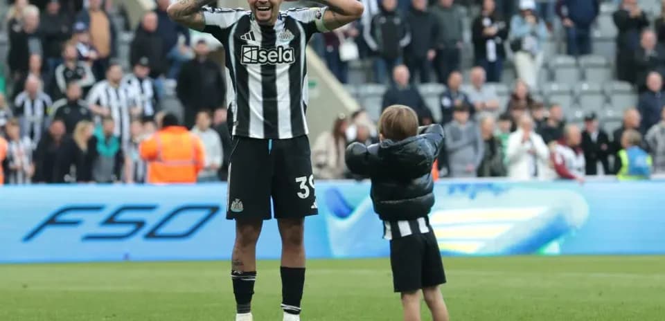 Joueur de Newcastle célébrant avec un enfant sur le terrain