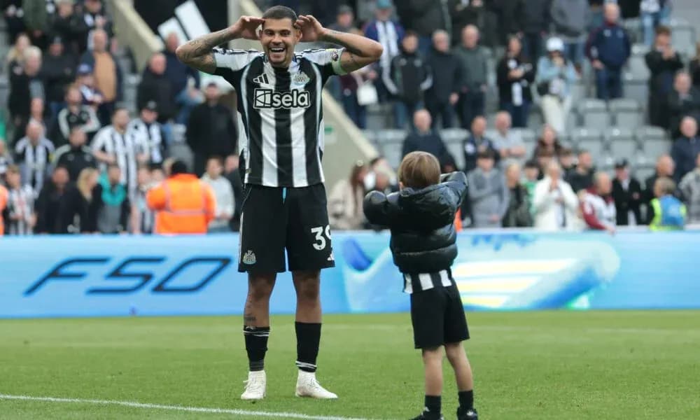 Joueur de Newcastle célébrant avec un enfant sur le terrain