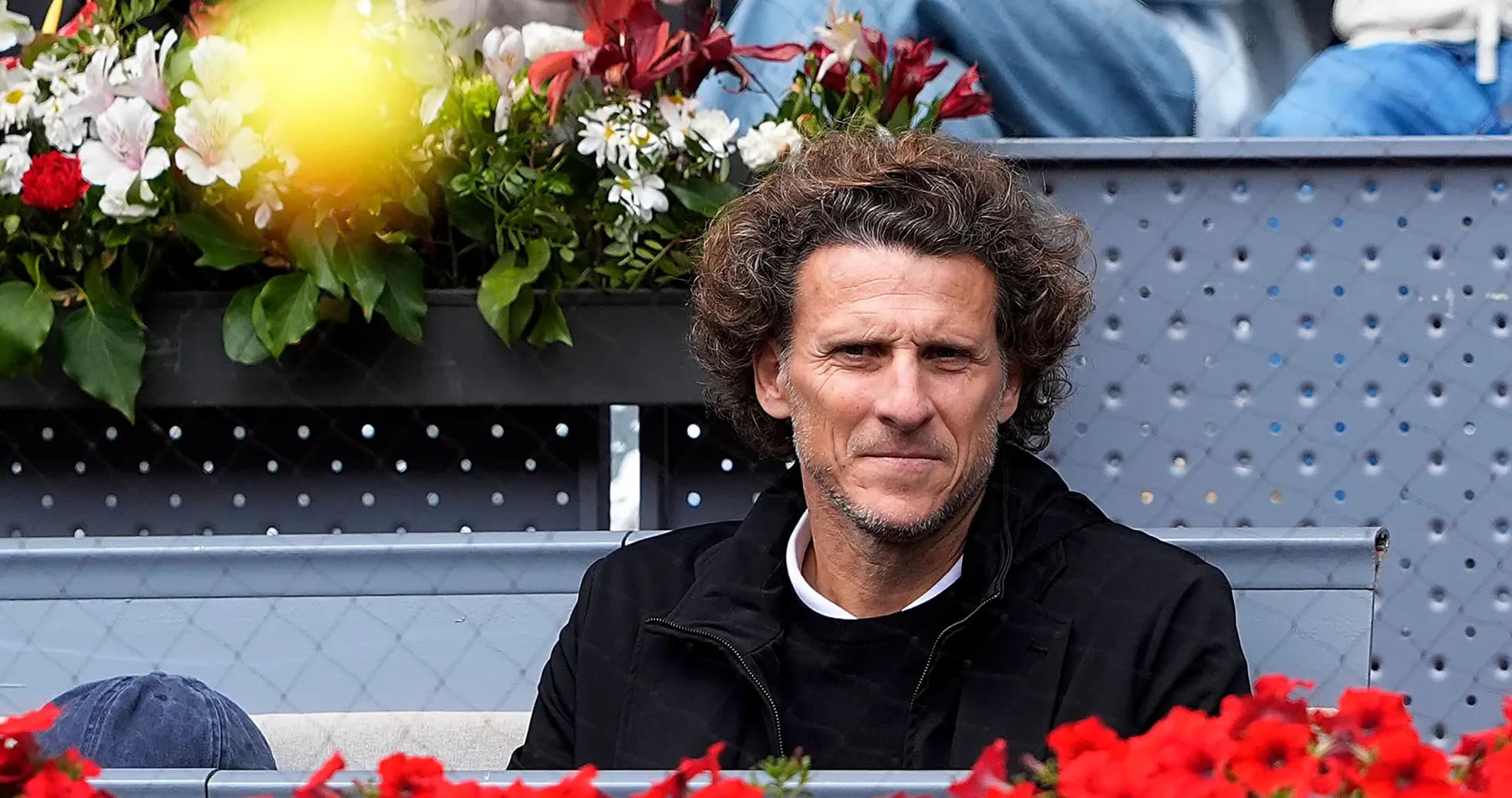 Homme assis devant des fleurs lors d'un événement sportif