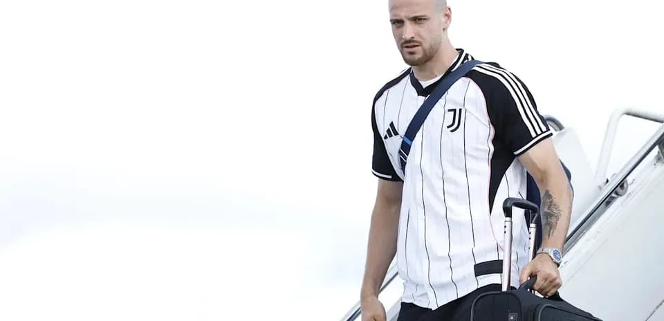Joueur de la Juventus descendant de l'avion avec une valise