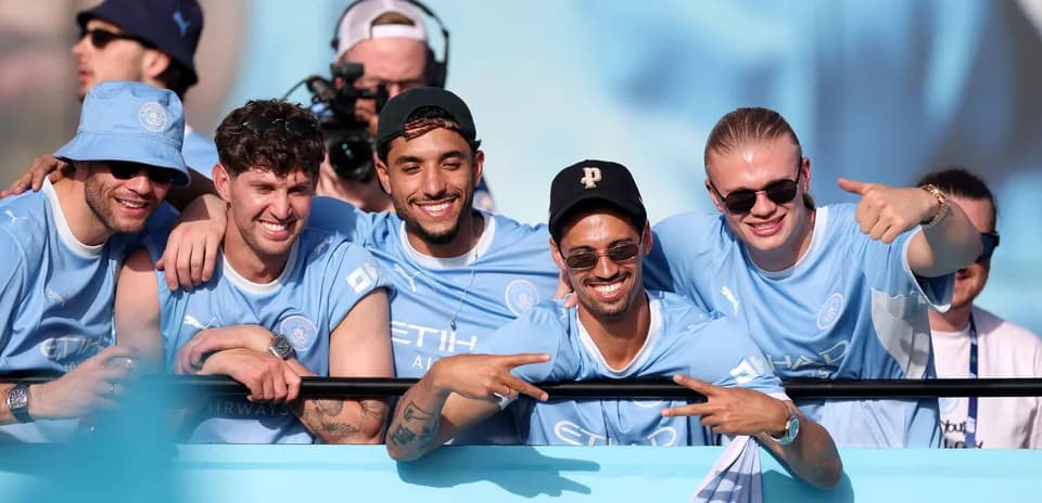 Groupe de supporters souriants en maillots de Manchester City